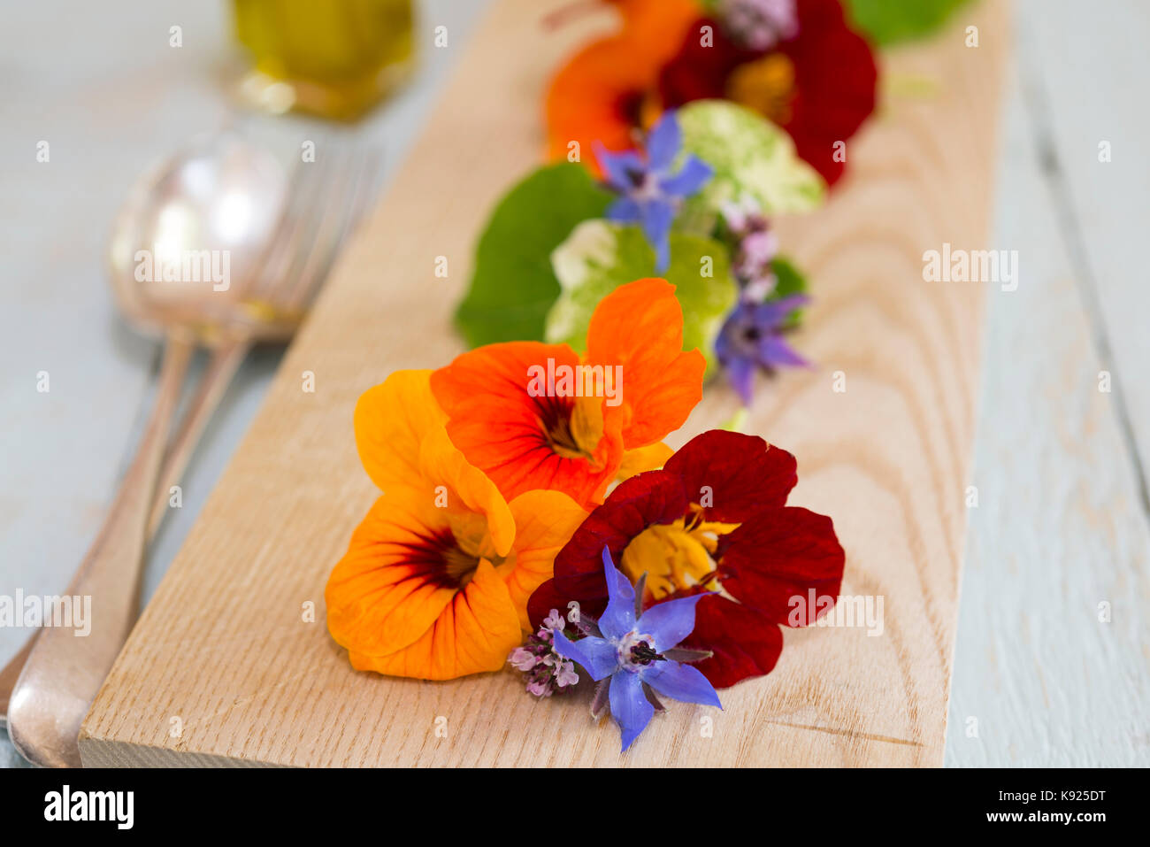Une salade de fleurs comestibles sur une planche de bois. Banque D'Images