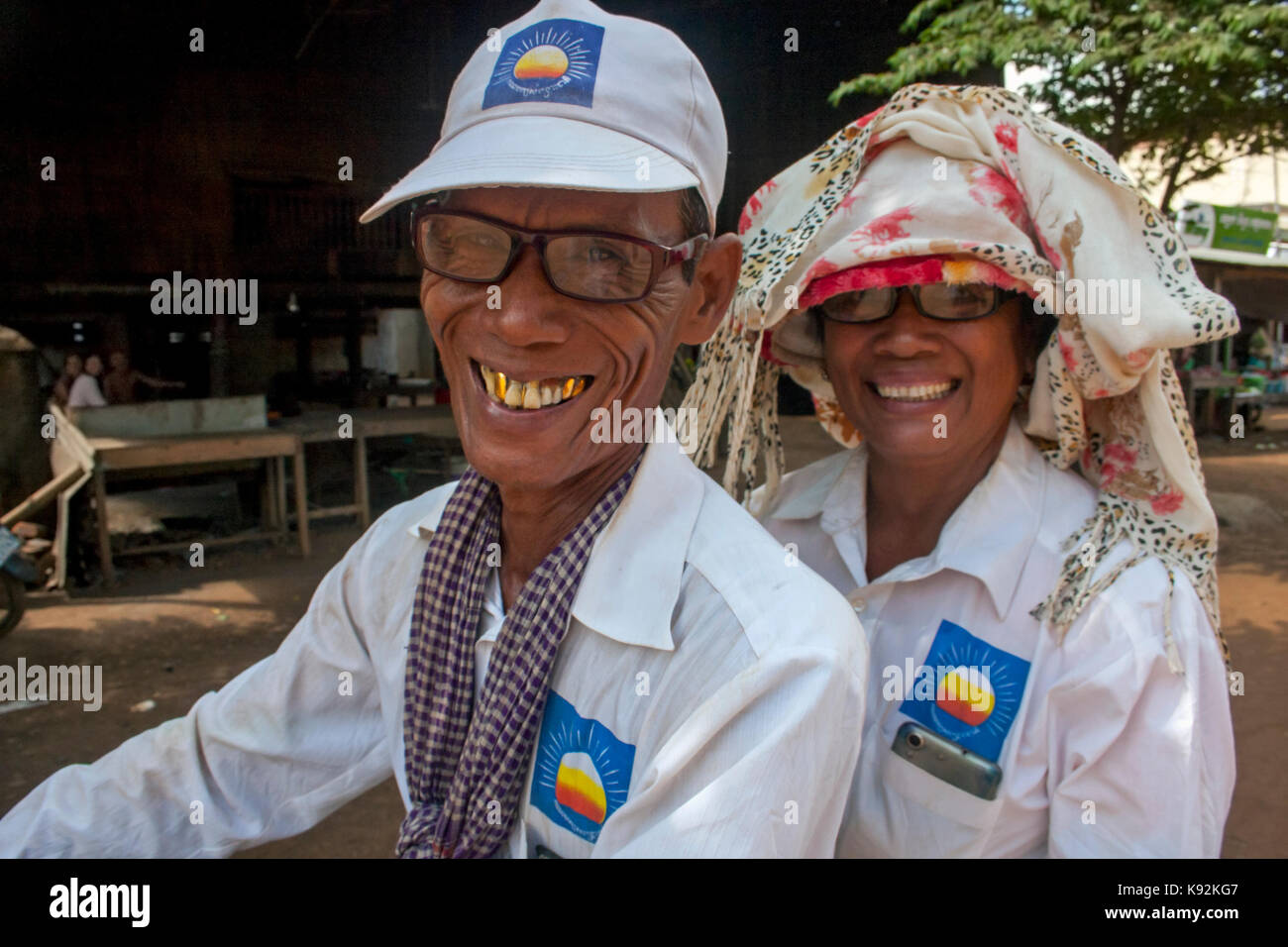 Un couple de personnes âgées est équitation une moto tout en portant des chapeaux cnrp parti d'opposition lors d'un rassemblement à chork, Tboung Khmum village province, Cambodge Banque D'Images