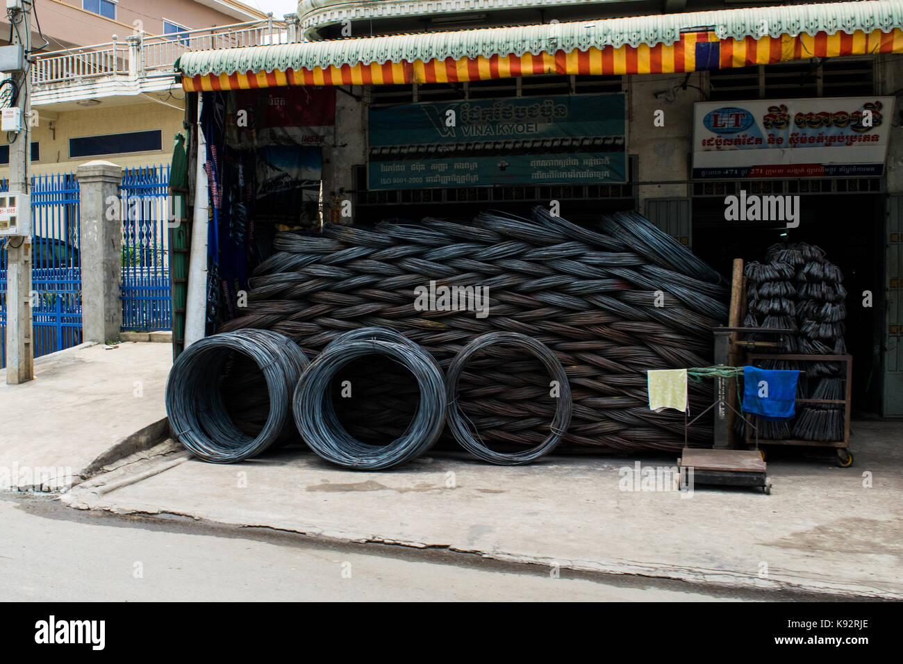 Un magasin de vente de matériel et les rouleaux de fil métallique. Rouleaux de fil sont empilés les uns sur les autres et s'affiche à l'extérieur du magasin à Phnom Penh, Cambodge Banque D'Images