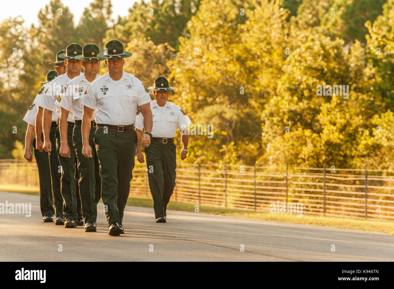 La formation du personnel d'application de la loi, ou d'exercice, instructeurs, marcher en formation pour saluer une nouvelle académie de police classe recruter le premier jour de la formation. Banque D'Images