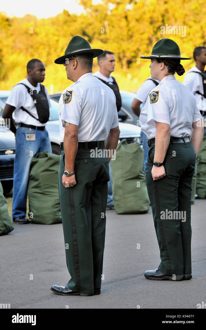 Deux instructeurs de forage de l'application de la loi, un homme et une femme, au garde à vous en face d'une nouvelle politique de formation de l'académie de la classe. Banque D'Images