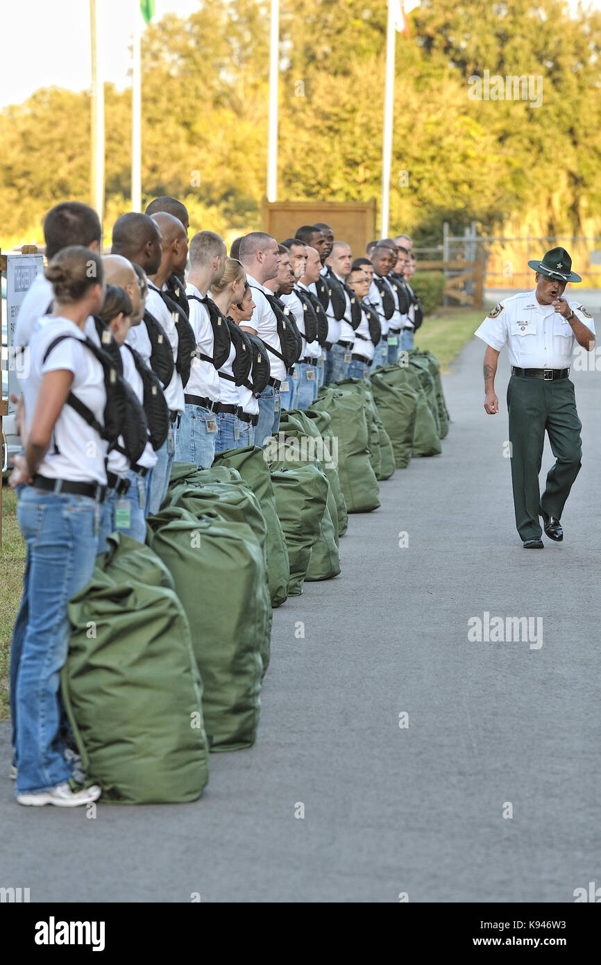 Law enforcement Academy instructeur de forage donne des instructions à une nouvelle recrue de la police classe car ils commencent leur première journée de stressant de la formation de la police. Banque D'Images