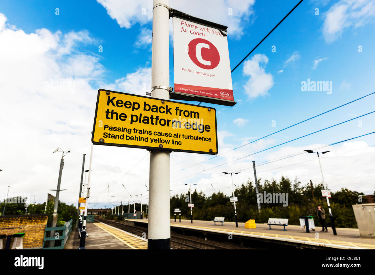 Panneau d'avertissement de train, gare de trains, d'avertissement de turbulence d'air cause signe, signe de danger de passage des trains, se tenir derrière la ligne jaune signe, uk Banque D'Images