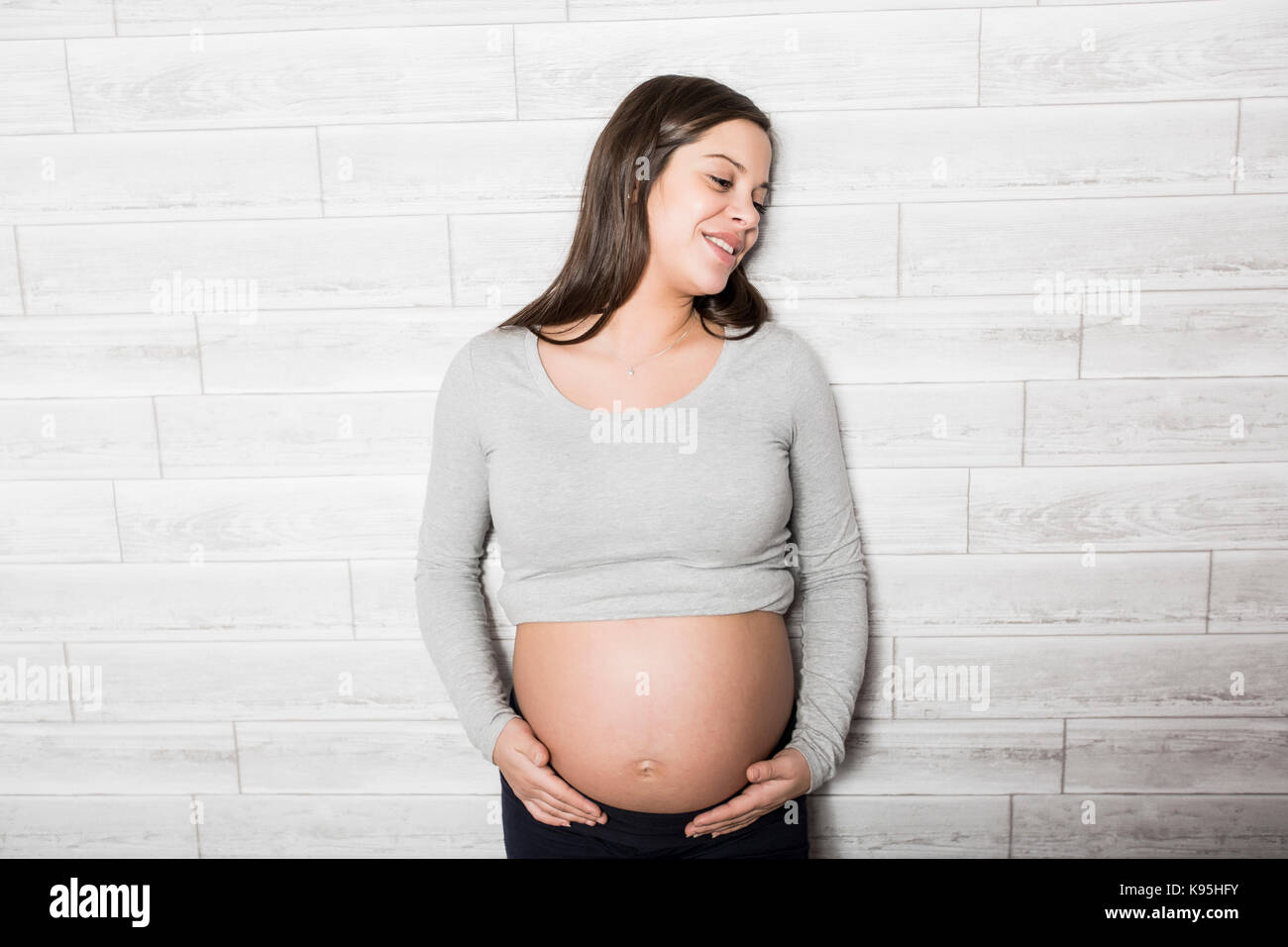 Femme enceinte en chambre de bébé Banque D'Images