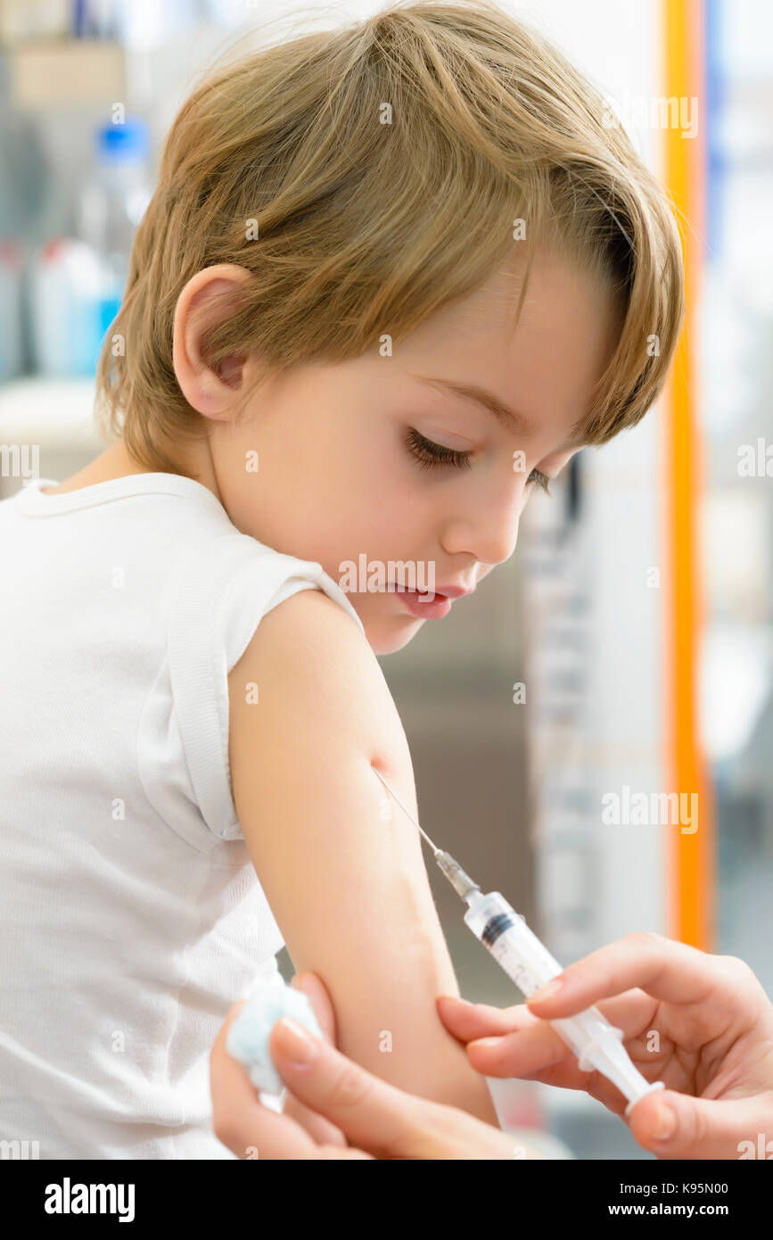 Cute boy étant injecté à la clinique Banque D'Images