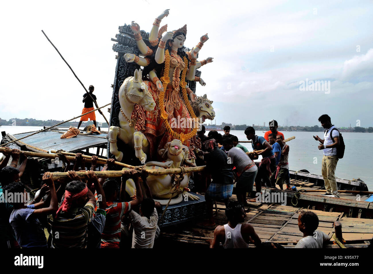 Une statue d'argile de la déesse hindoue Durga indienne est amené d'un atelier en kumartoli l'idole, village des décideurs, en bateau sur le Gange . Banque D'Images