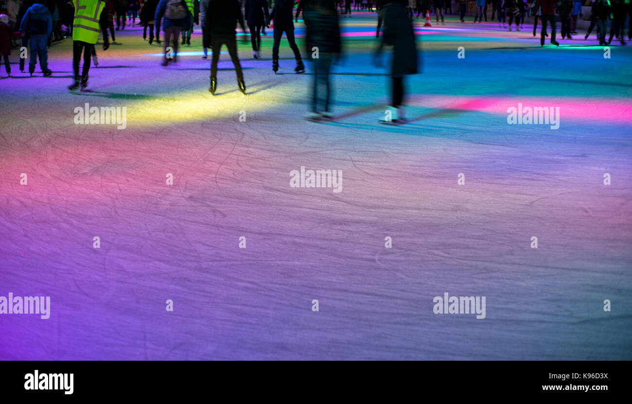 Patineurs sur une patinoire en lumières colorées au soir. copier l'espace. Banque D'Images