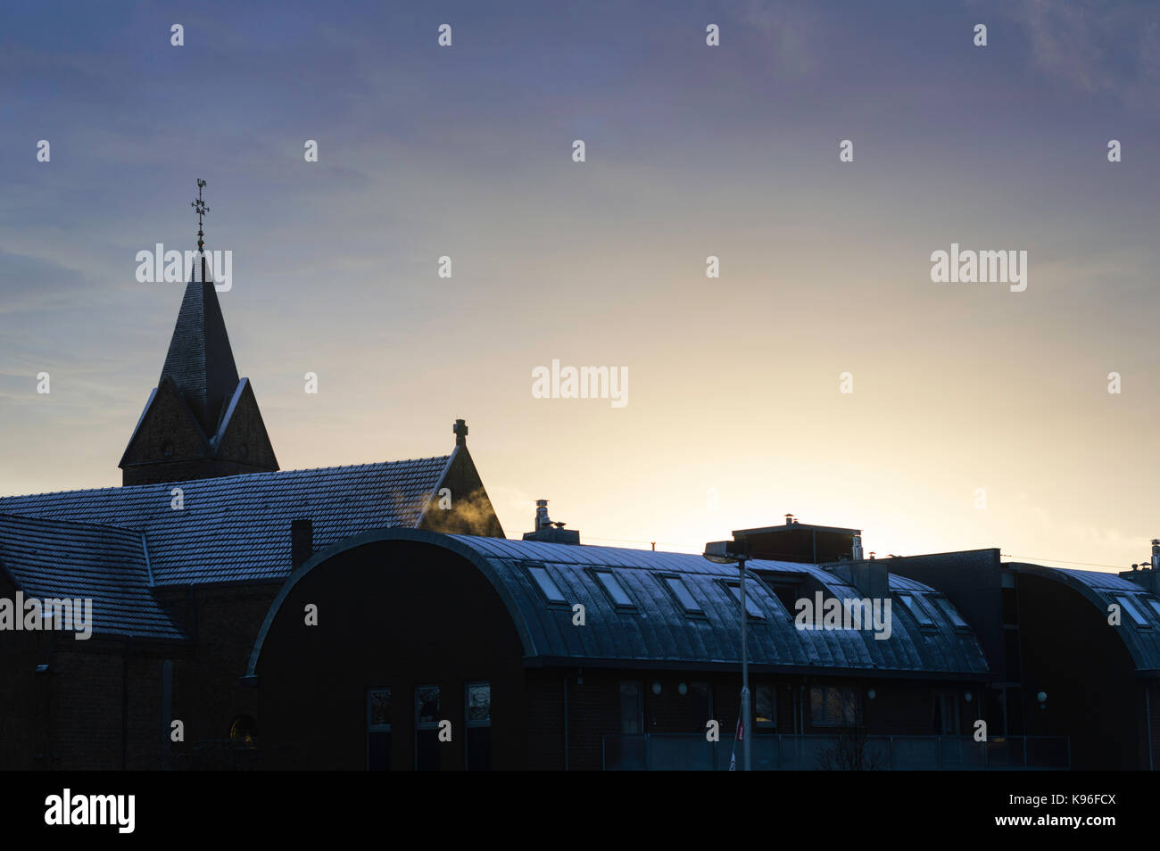 Toits enneigés et église sur un matin d'hiver Banque D'Images