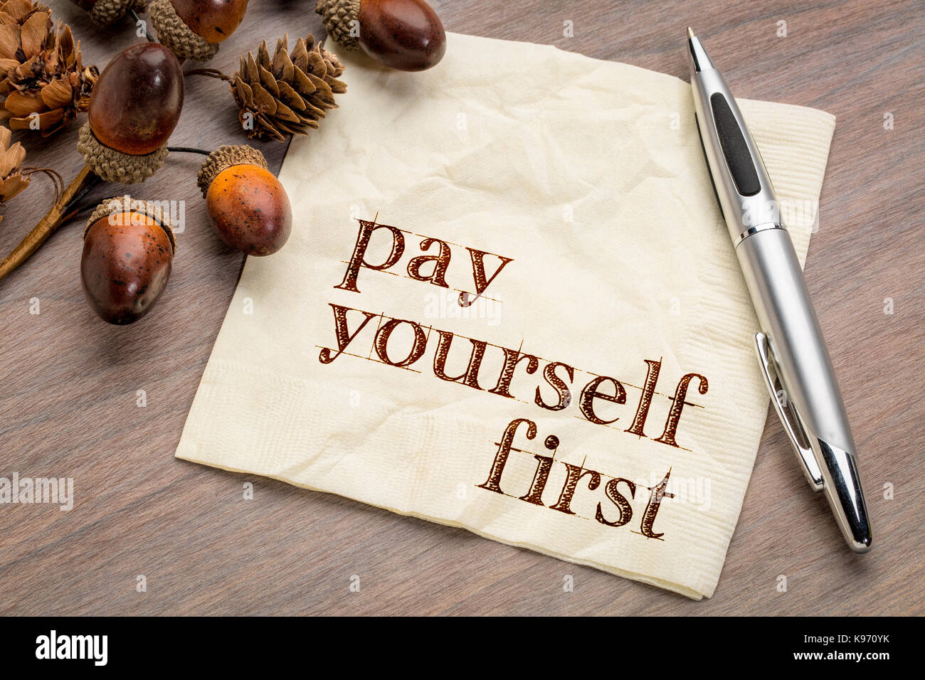 Payez-vous en premier - conseils financiers, l'écriture sur une serviette avec acorn et décoration cône Banque D'Images