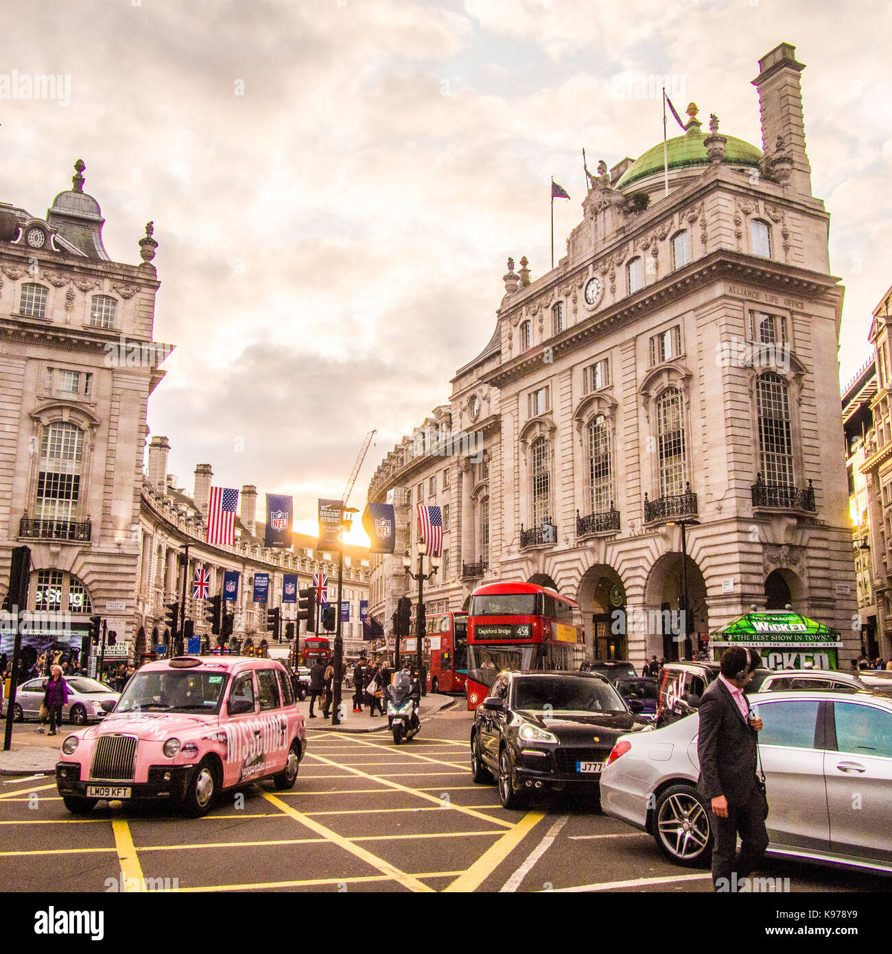 Taxi rose navigue autour de Picadilly Circus avec Regent Street derrière Banque D'Images