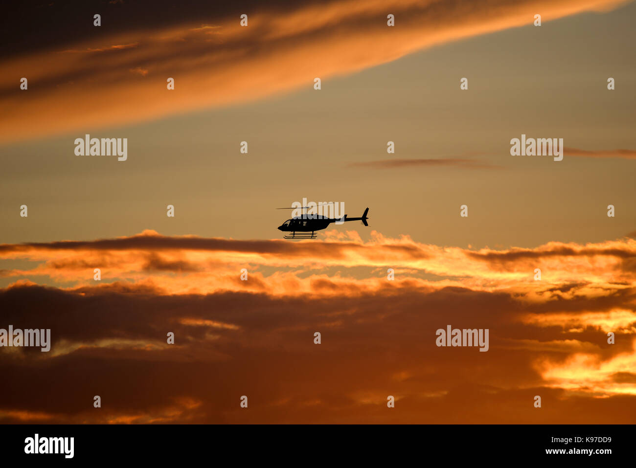 Hélicoptère Bell Jet Ranger volant au coucher du soleil après le Goodwood Revival 2017 Banque D'Images