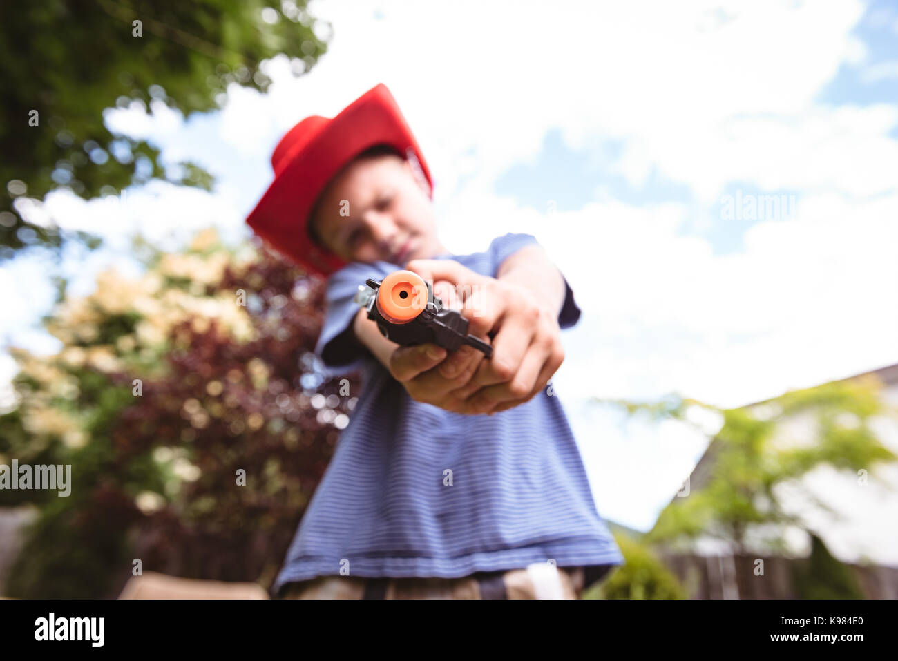 Cute boy faisant semblant d'être un cowboy in playground Banque D'Images Cute boy faisant semblant d'être un cowboy in playground Banque D'Images