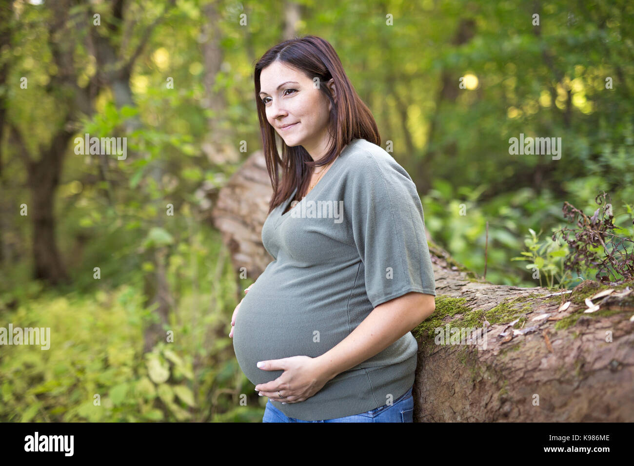 Une belle femme enceinte détente sur un parc Banque D'Images
