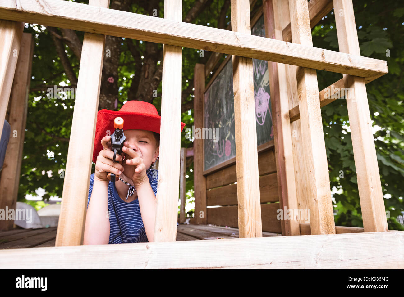 Cute boy faisant semblant d'être un cowboy in playground Banque D'Images Cute boy faisant semblant d'être un cowboy in playground Banque D'Images