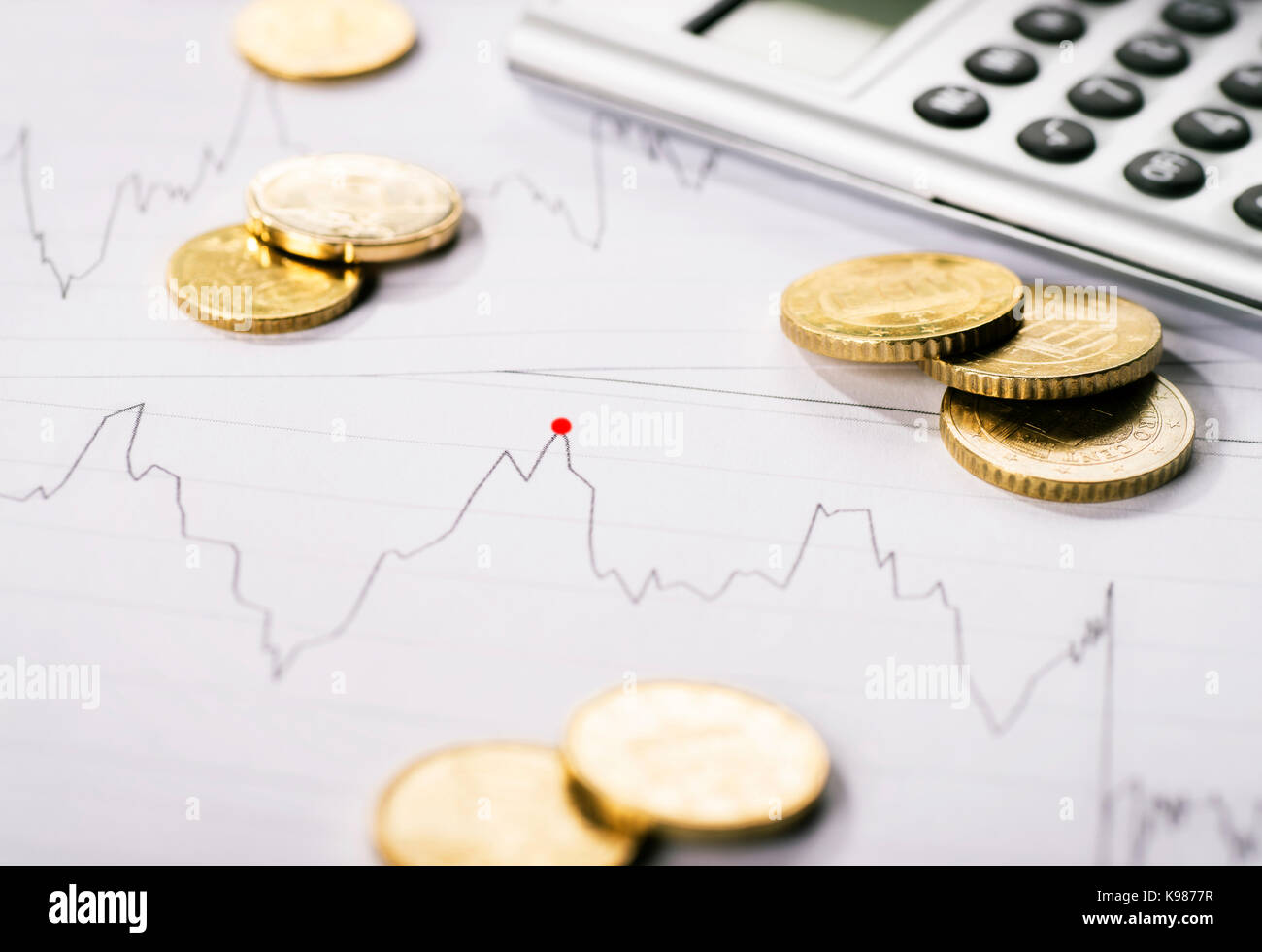 Diagramme montre la tendance d'un cours et est entouré par des pièces de monnaie et une calculatrice. Banque D'Images