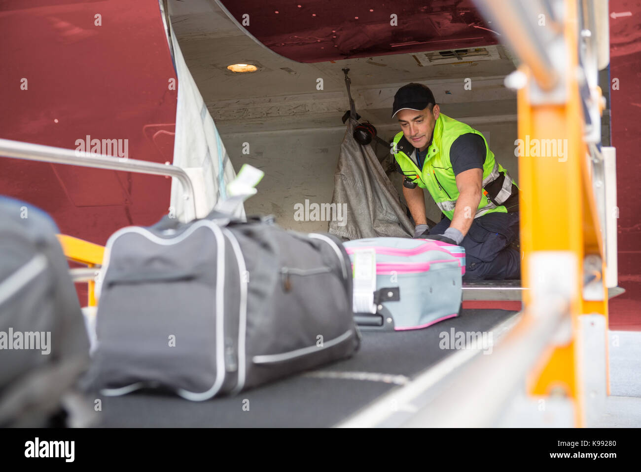 Le placement des travailleurs sur les tapis à bagages de l'avion pour  décharger Photo Stock - Alamy