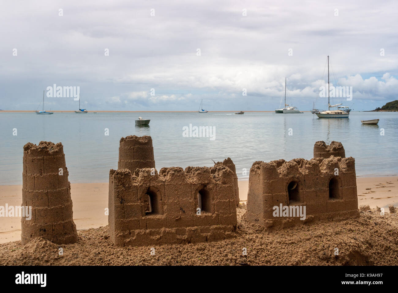 Châteaux de sable sur la plage et yachts amarrés dans la baie - une destination de vacances idéale. Banque D'Images