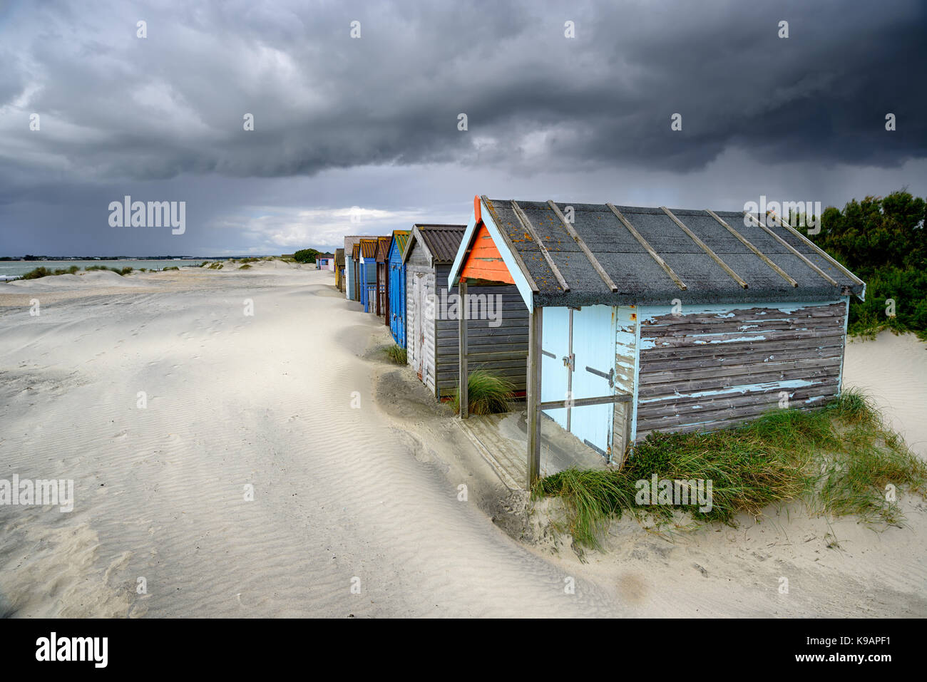 Cabines de plage sous un ciel d'orage spectaculaire à West Wittering sur la côte du Sussex de l'Ouest Banque D'Images
