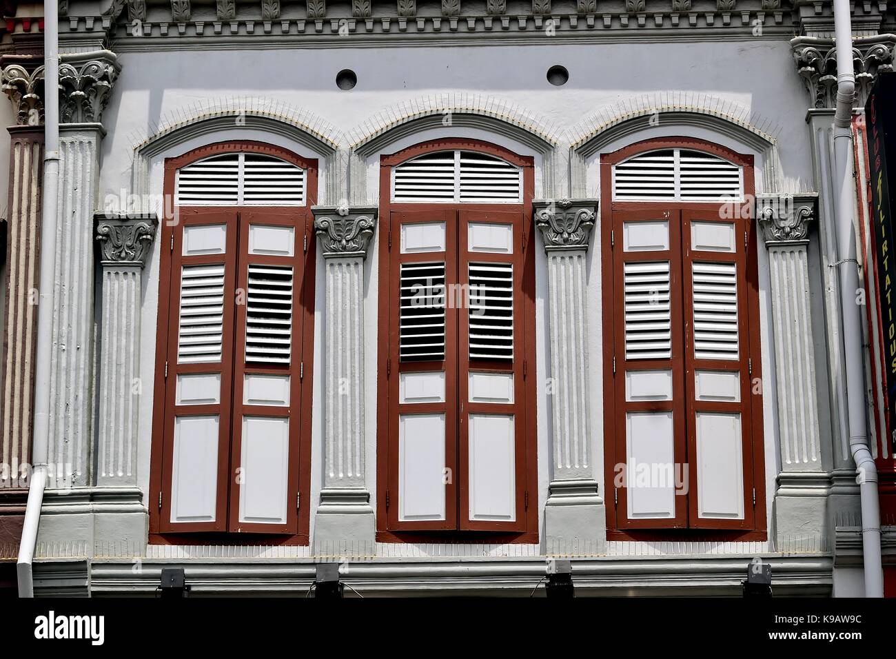 Singapour extérieur de maison boutique traditionnelle avec fenêtres, colonnes et orné de bois rouge dans l'majorquines duxton historique district. Banque D'Images