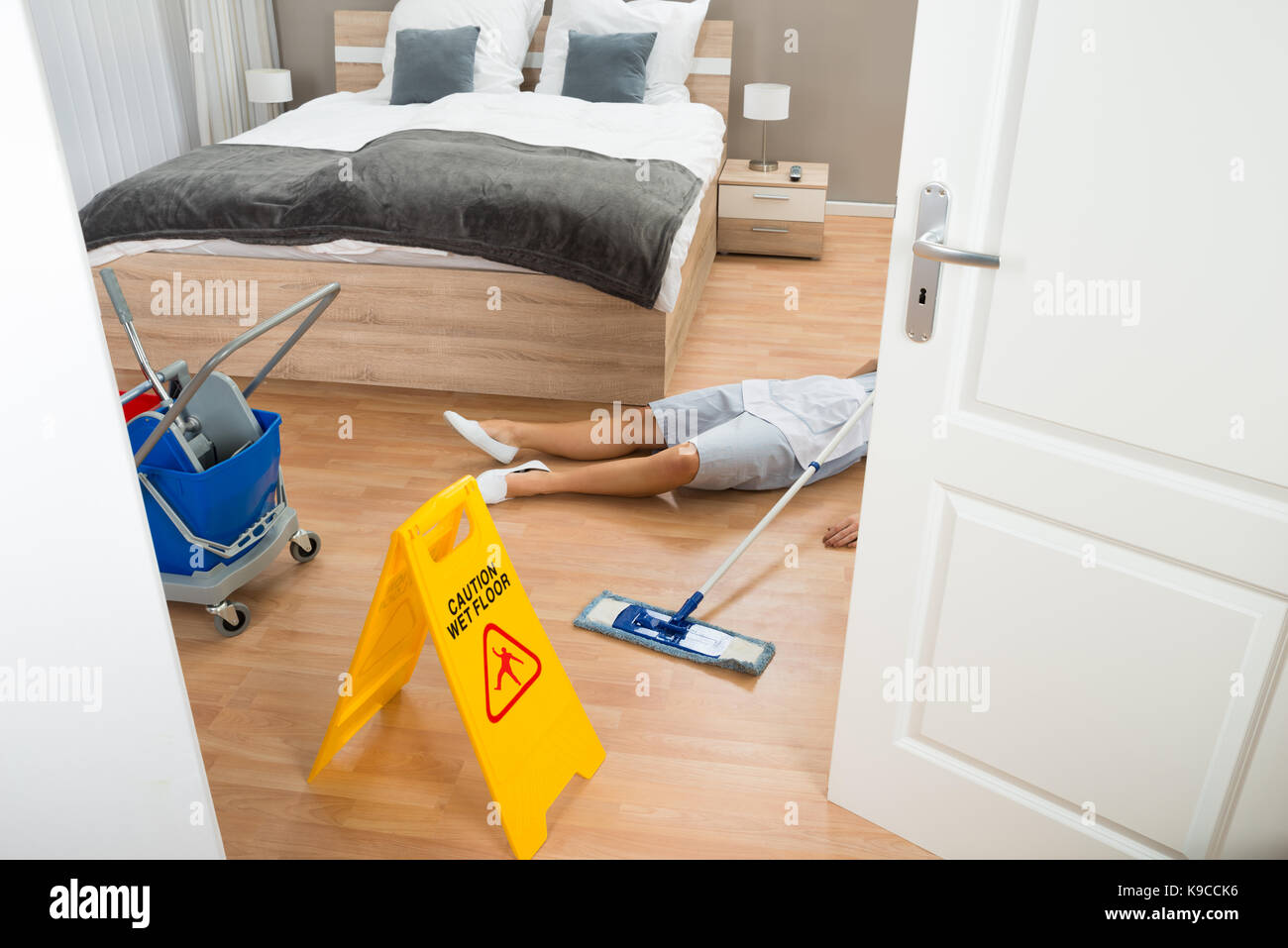 Femme de ménage a un accident au travail, lors du nettoyage de chambre d'hôtel Banque D'Images