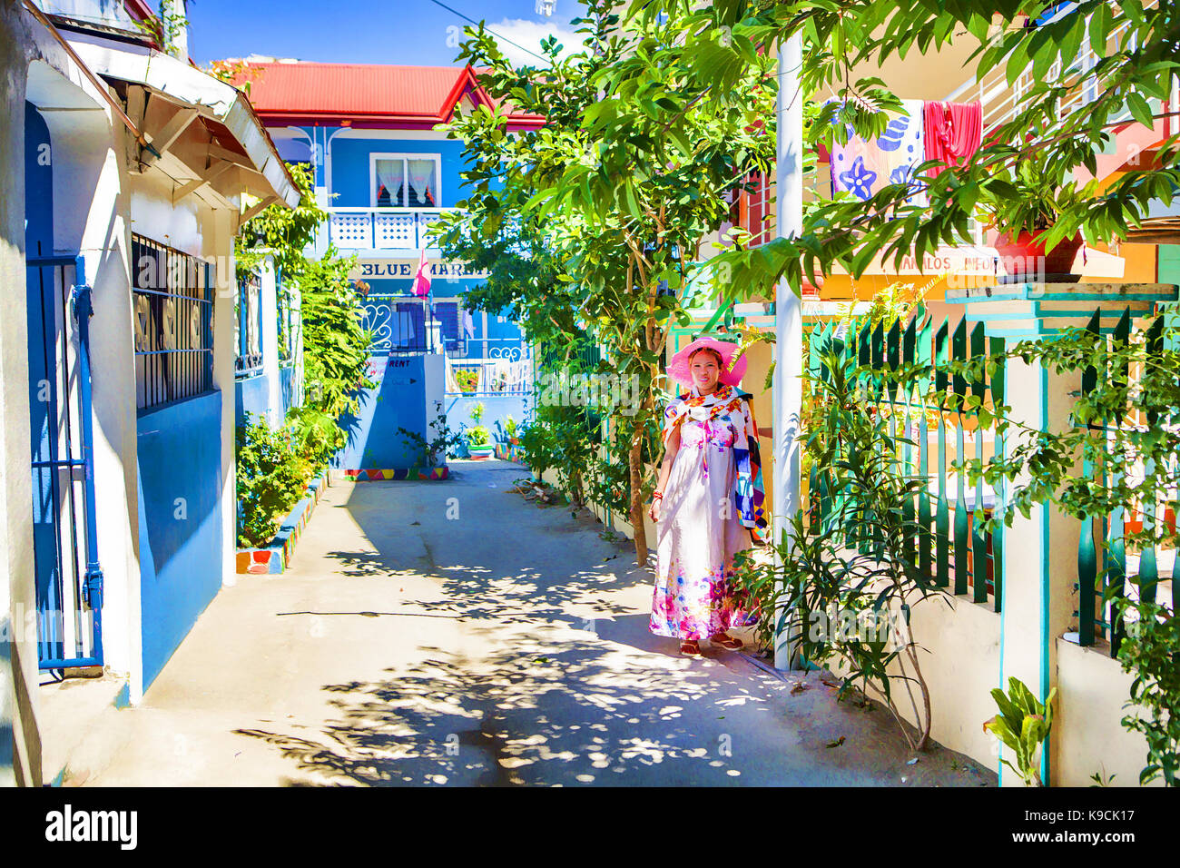 Une jolie femme asiatique portant des vêtements de plage pose à la porte de son beach hotel à White Beach à Puerto Galera, l'île de Mindoro oriental, Philippines. Banque D'Images