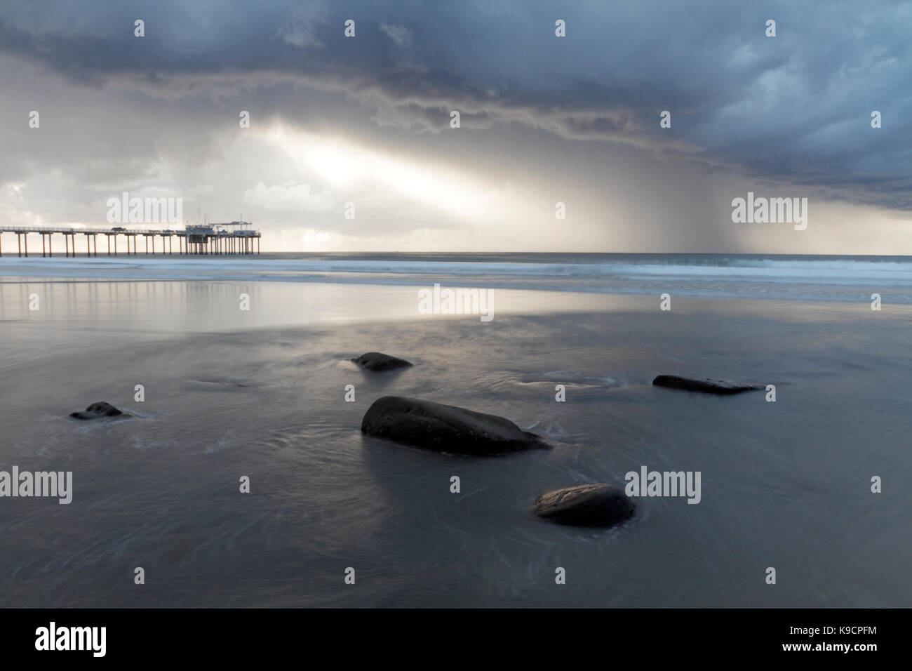 Jetée de Scripps, La Jolla, San Diego, vue pendant un orage de la plage de rochers en premier plan et dramatique de l'éclairage. Banque D'Images