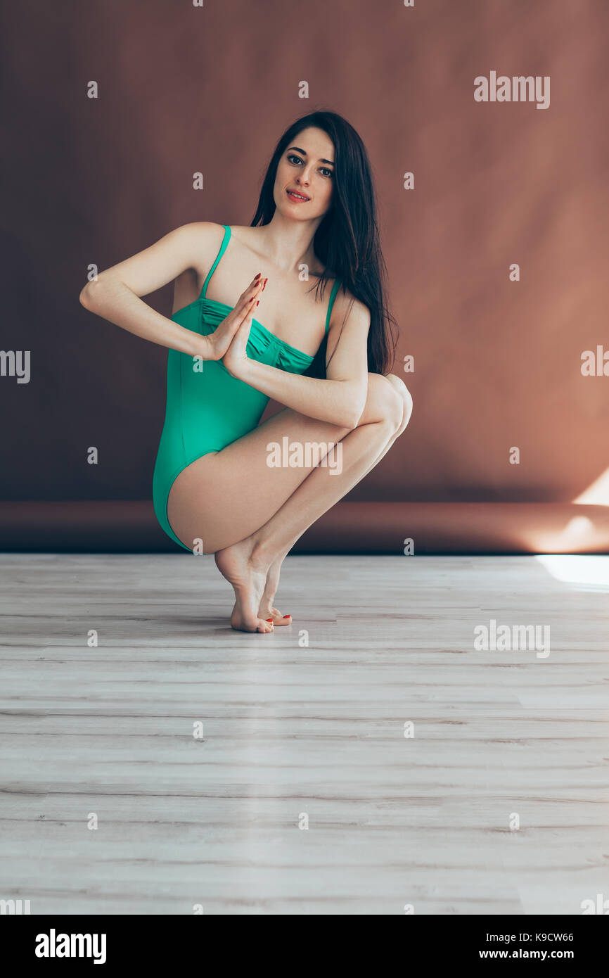 Young Beautiful woman doing yoga asana pieds posent des prapadasana variation sur studio Banque D'Images