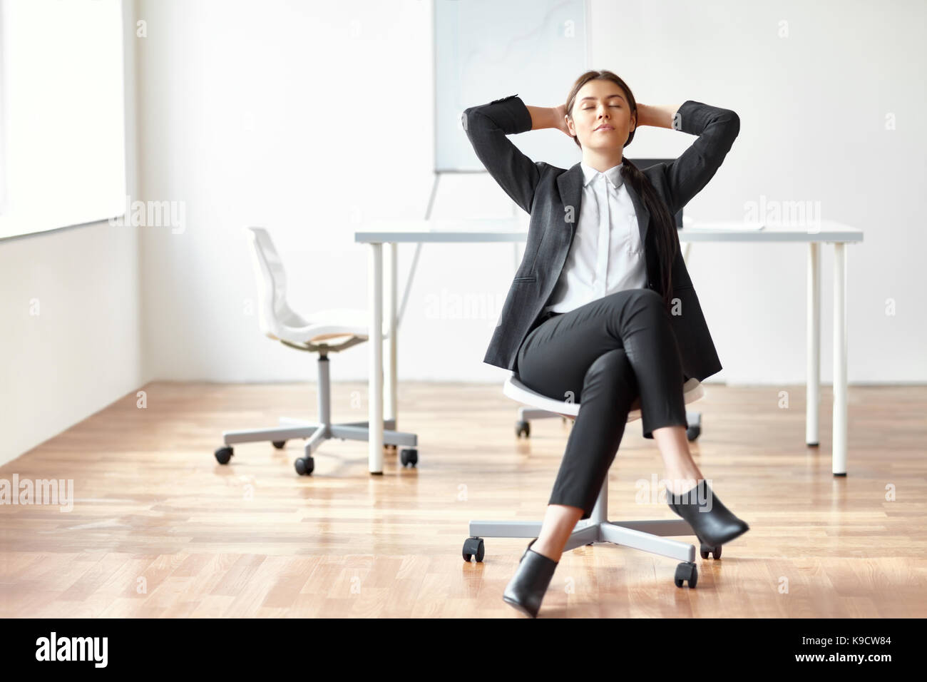 Portrait of young woman sitting on chair dans le bureau Banque D'Images