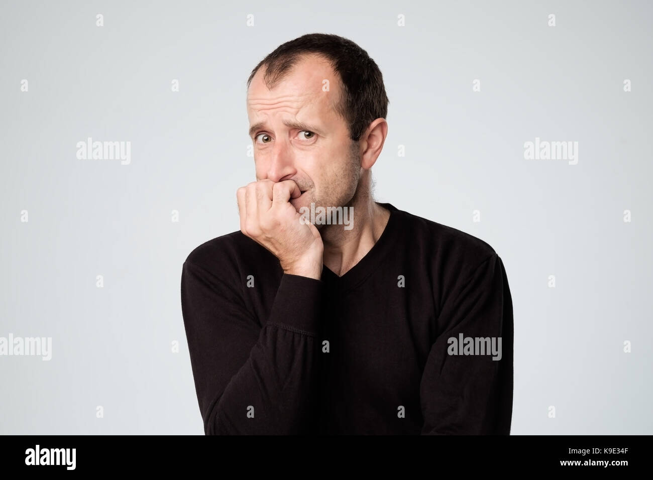 L'homme inquiet tente de se rappeler quelque chose. Il s'inquiète et attend avec doute at camera Banque D'Images