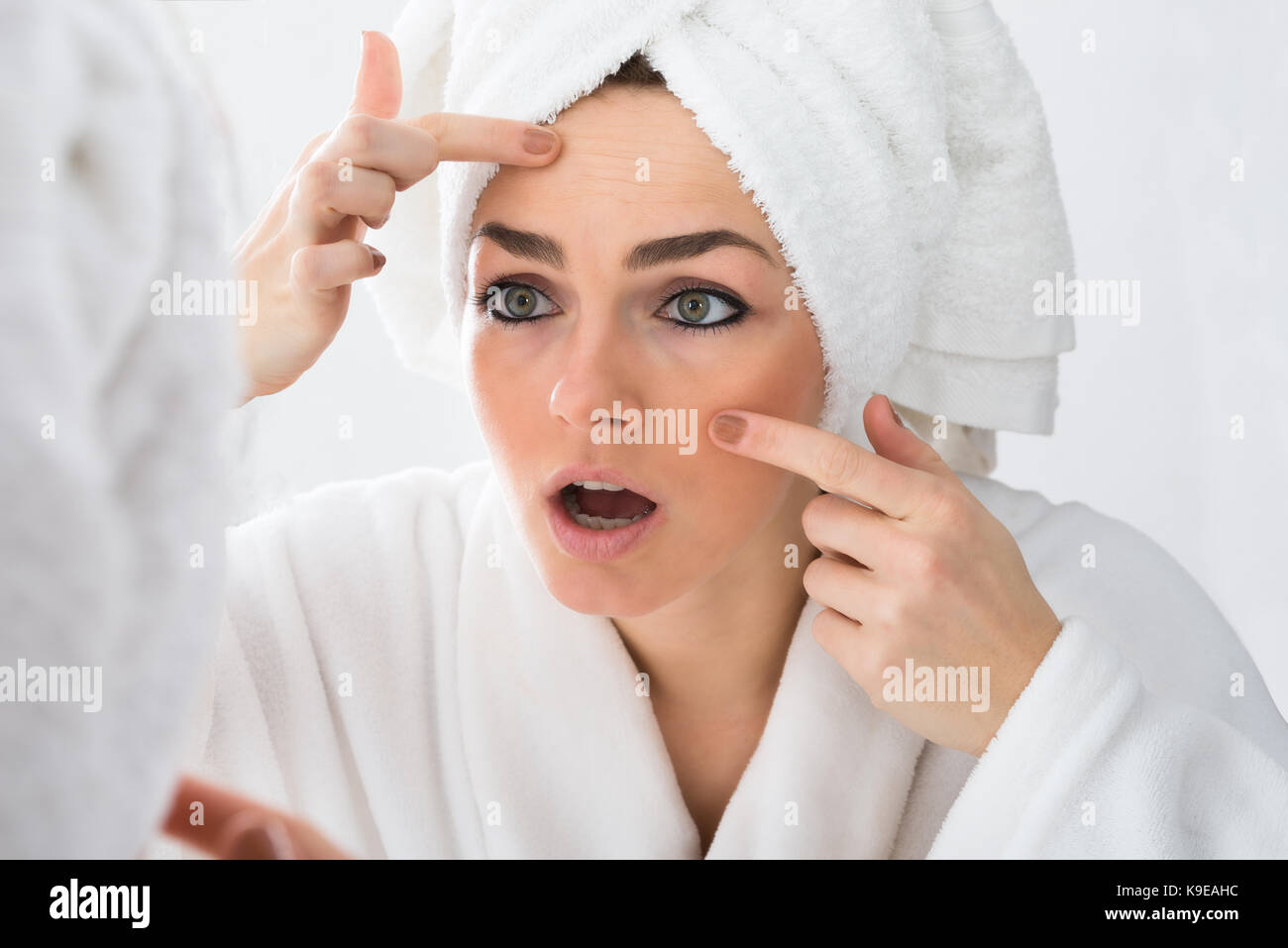 Close-up of Worried Woman Looking At bouton sur la face en miroir Banque D'Images