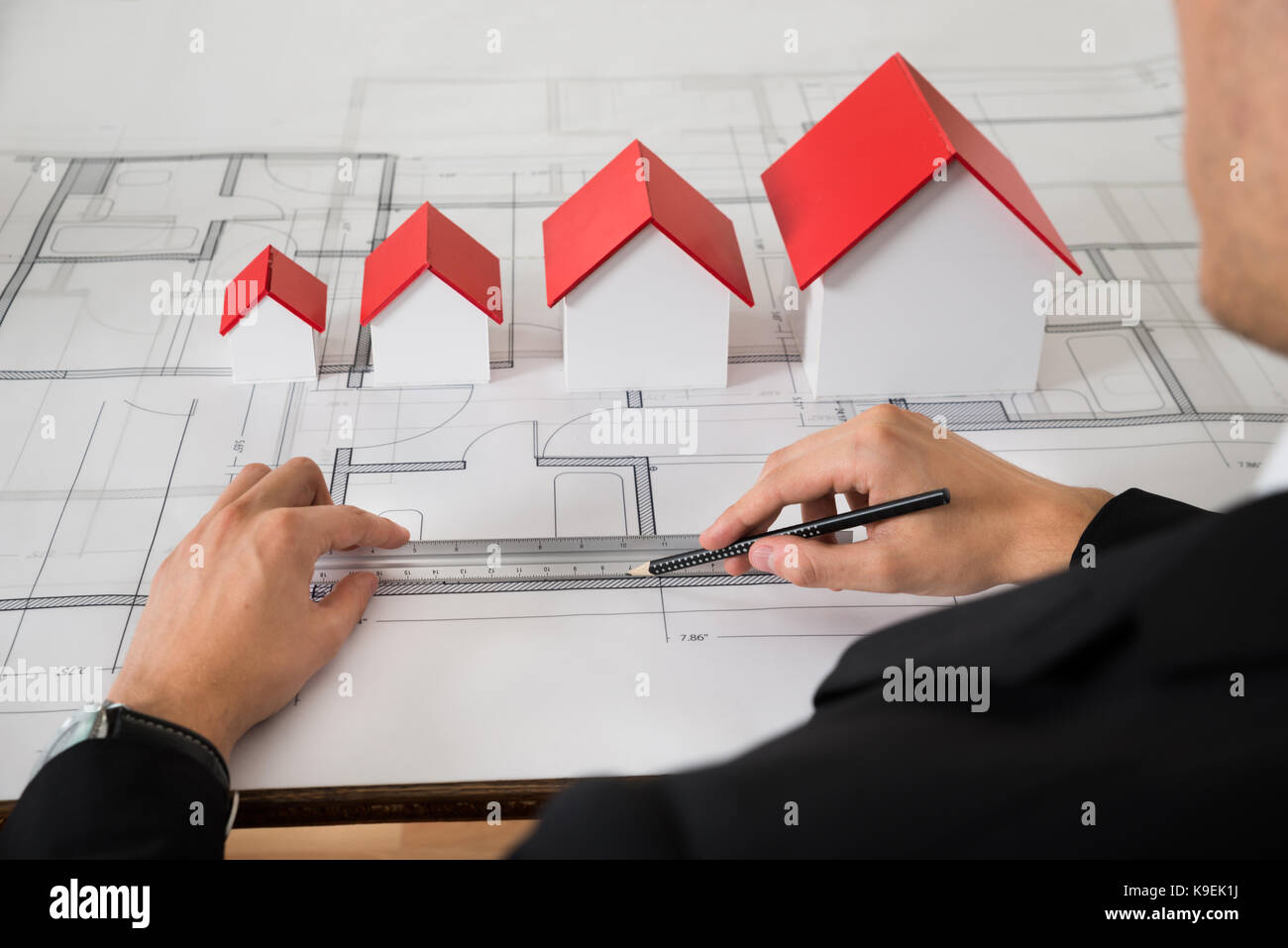 Close-up de l'architecte de différentes tailles, modèles de maison sur blueprint in office Banque D'Images