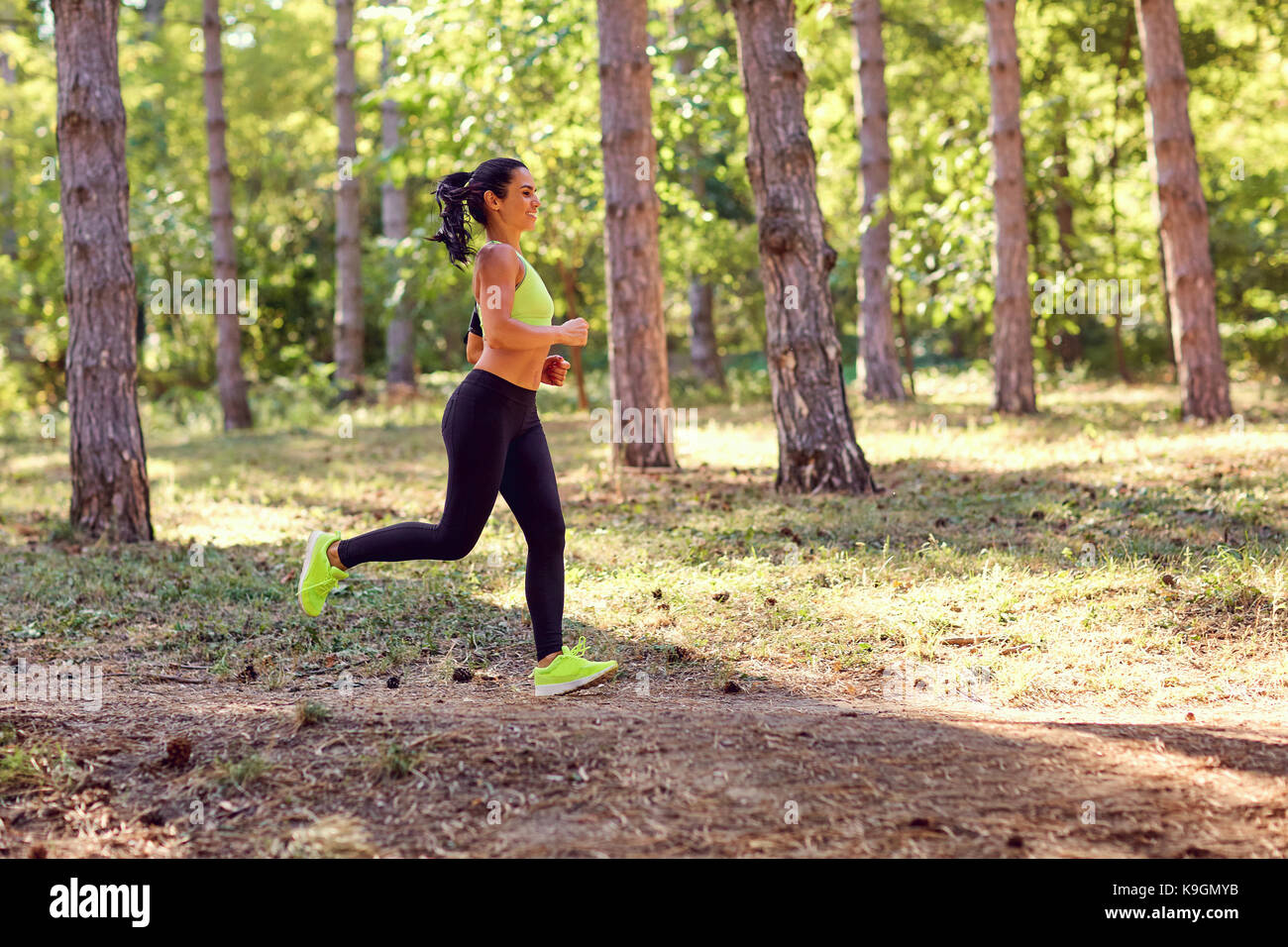 Brunette girl sports traverse la forêt. Banque D'Images