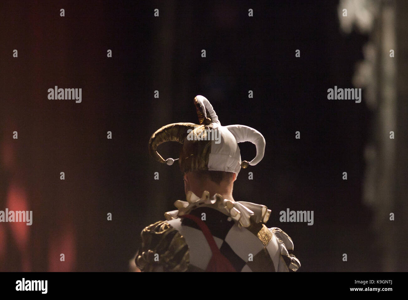 Outfit, théâtre, excitation concept. l'arrière du jeune homme habillé en costume du fou avec les imbéciles drôle et lumineux avec veste noir et rendez-vous Banque D'Images