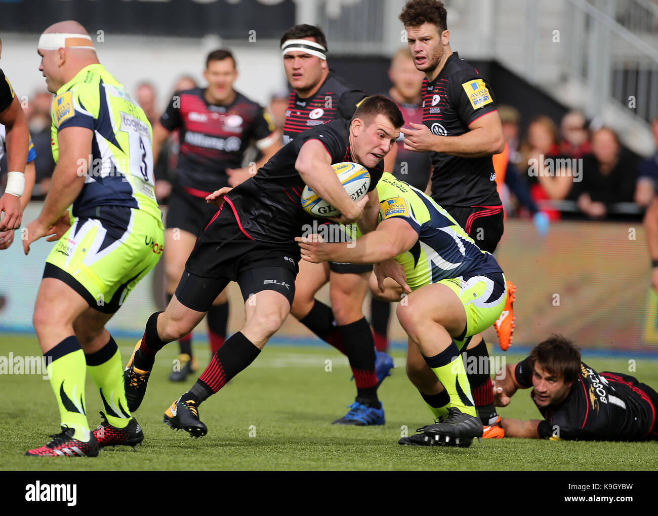 Saracens' ben spencer est abordé par sale sharks' ross Harrison pendant le match aviva premiership à barnet copthall, Londres. Banque D'Images