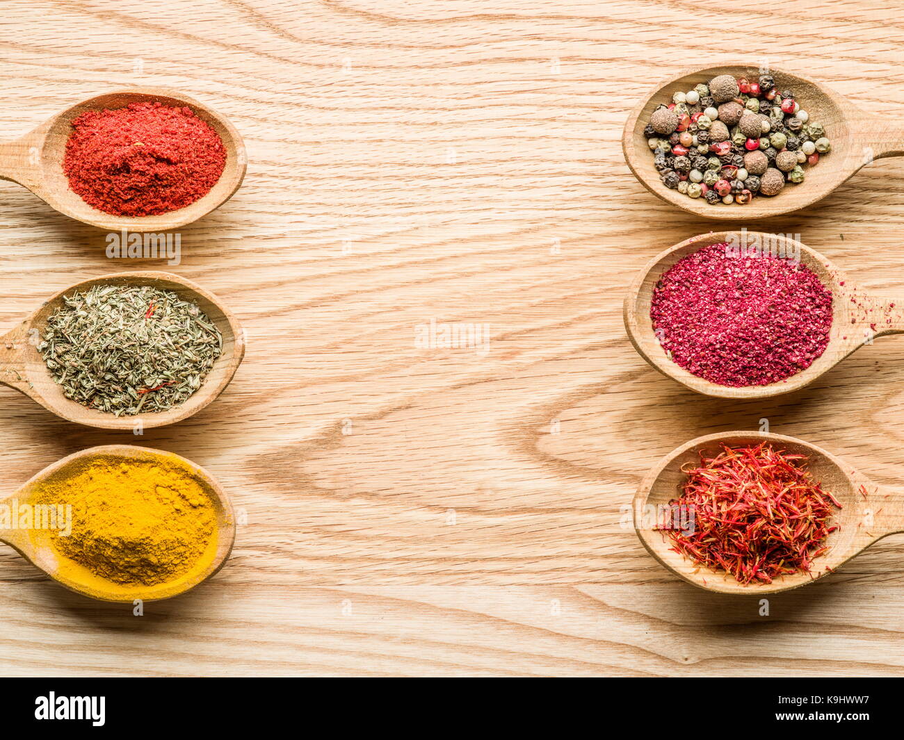 Assortiment d'épices colorées dans l'cuillères en bois sur la table en bois. Banque D'Images