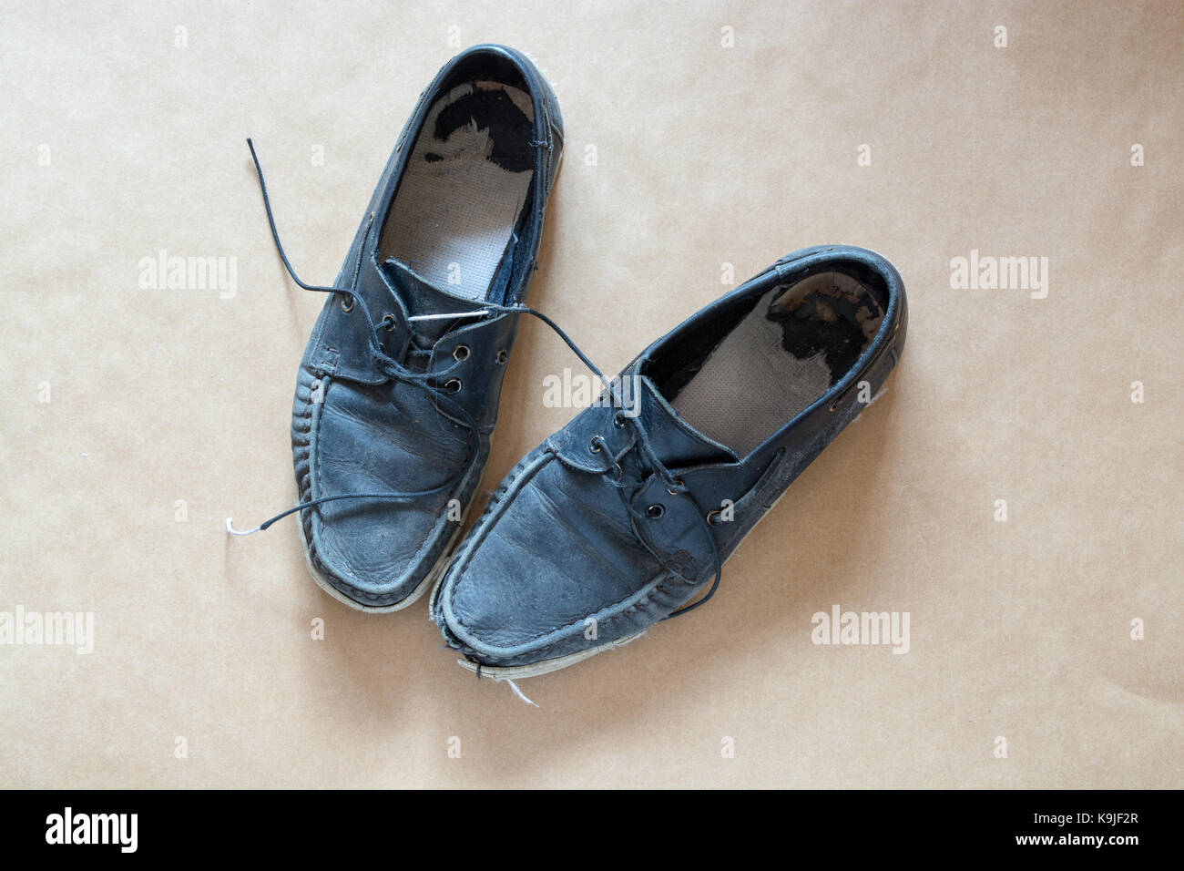 Vieux hommes, chaussures bleu cuir utilisé - une paire en mauvais état et éclaboussé de peinture blanche. Les lacets défaits Banque D'Images