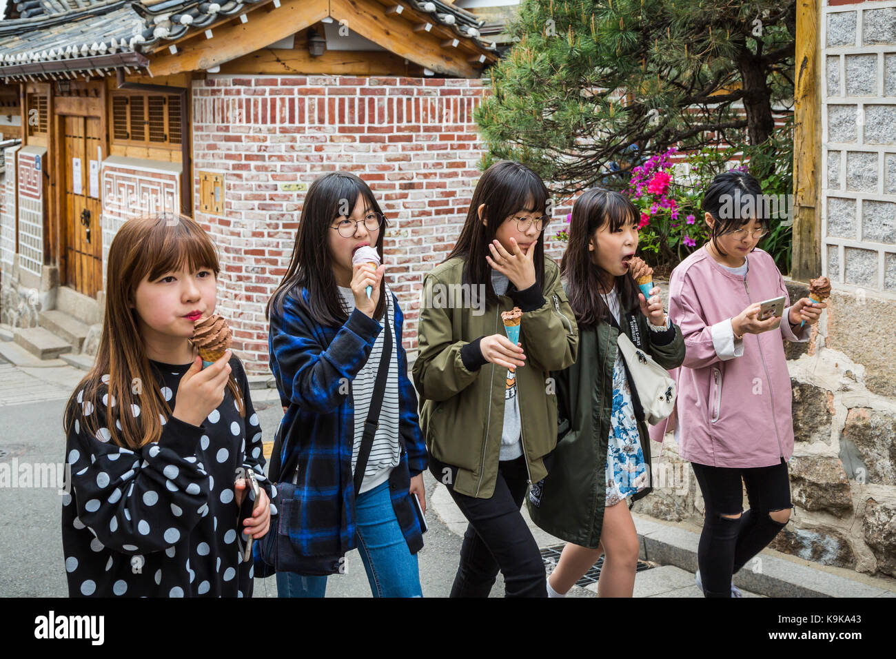 Les touristes coréens la consommation de crème glacée dans la rue au village de Bukchon, Séoul, Corée du Sud, en Asie. Banque D'Images