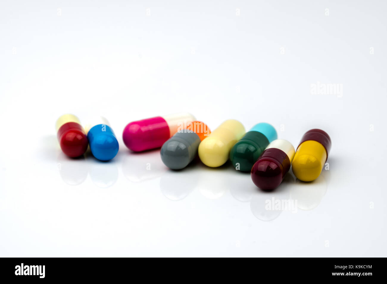 Capsules comprimés d'antibiotique colorés sur fond blanc avec copie espace. La résistance aux médicaments, l'utilisation d'antibiotiques avec raisonnable, la politique de santé et hea Banque D'Images