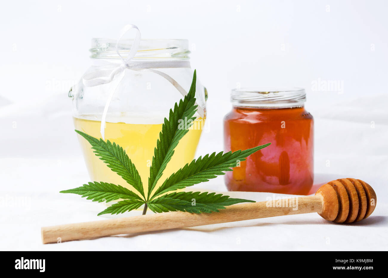 Feuilles de marijuana et doux le miel dans un pot Banque D'Images