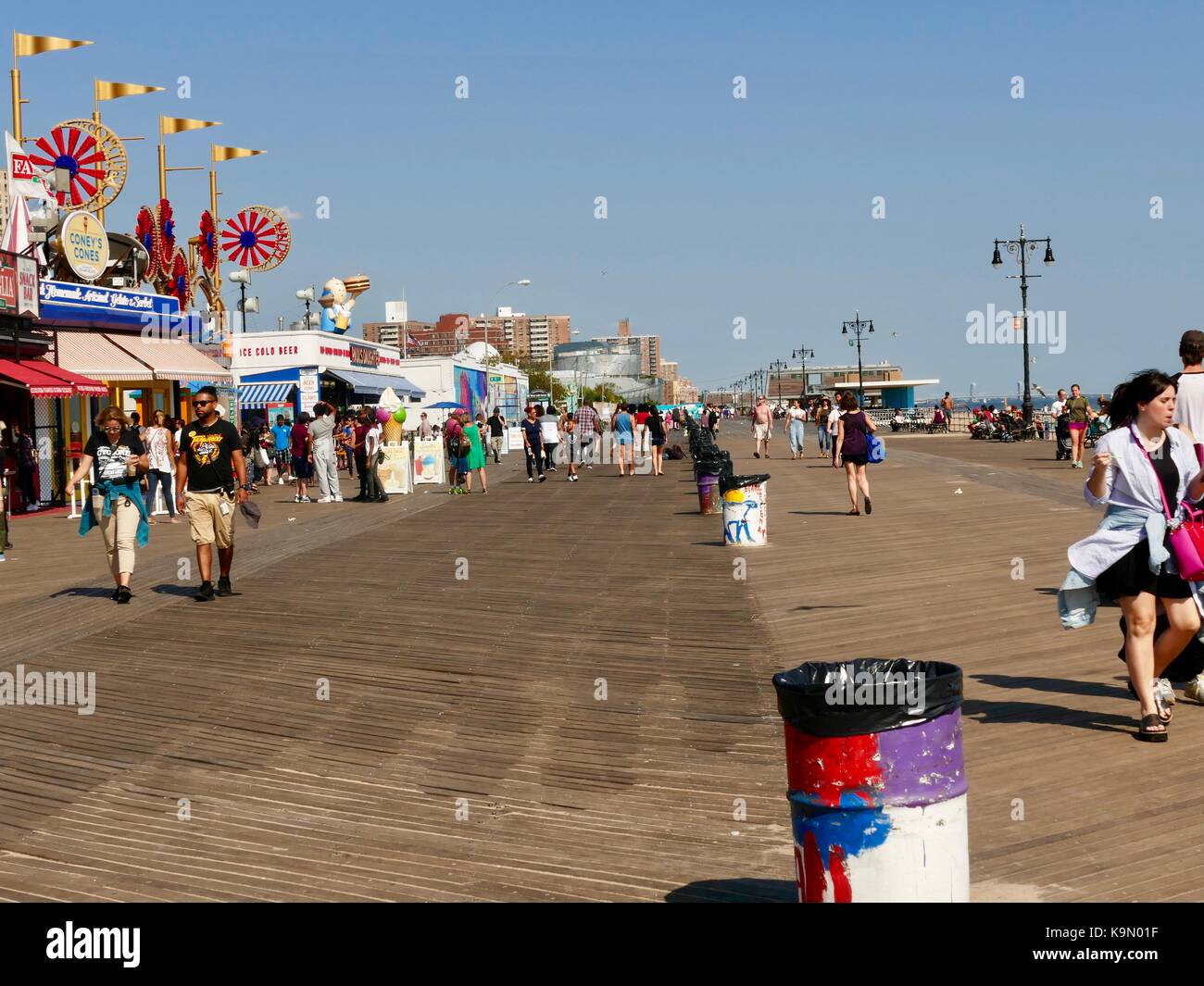 Foule de gens qui marchent sur la promenade à Coney Island, journée très ensoleillée, fin août, New York, NY, USA. Banque D'Images