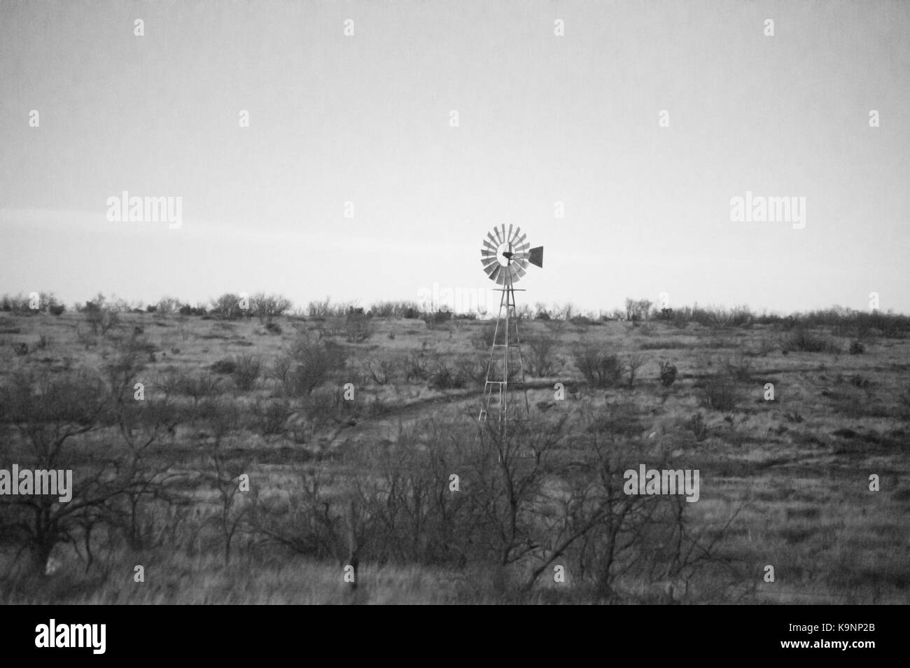 Un coup de noir et blanc d'un vieux moulin au milieu d'une plaine. Banque D'Images
