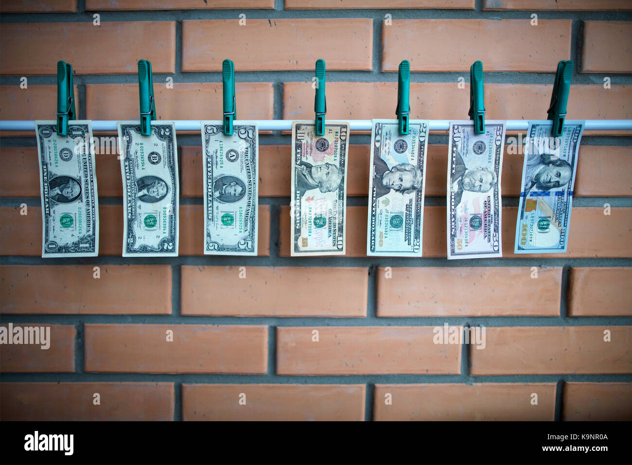 Ensemble de projets de 1,2,5,10,20,50,100 dollars usa sont le séchage sur un lattis métallique blanc avec Banque D'Images