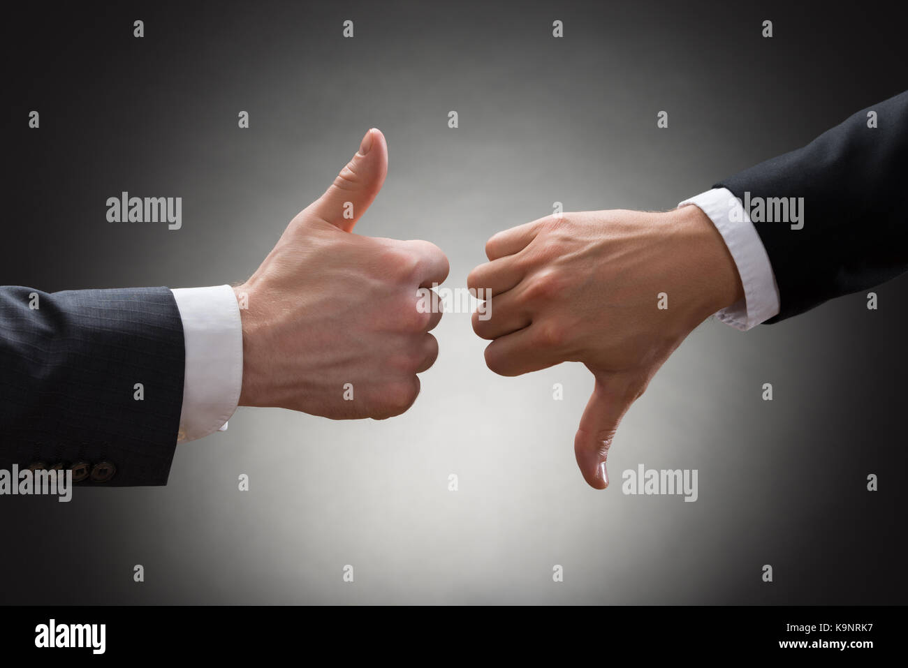 Close-up of two businesspeople hands showing thumb up et le pouce vers le bas sign Banque D'Images