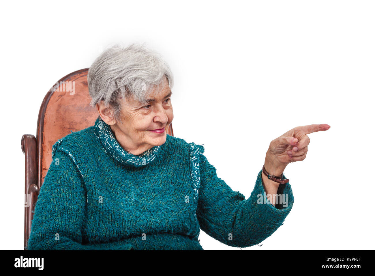 Vieille Femme poiting son doigt de gauche à quelque chose et à la recherche pour elle, isolé sur un fond blanc. Banque D'Images