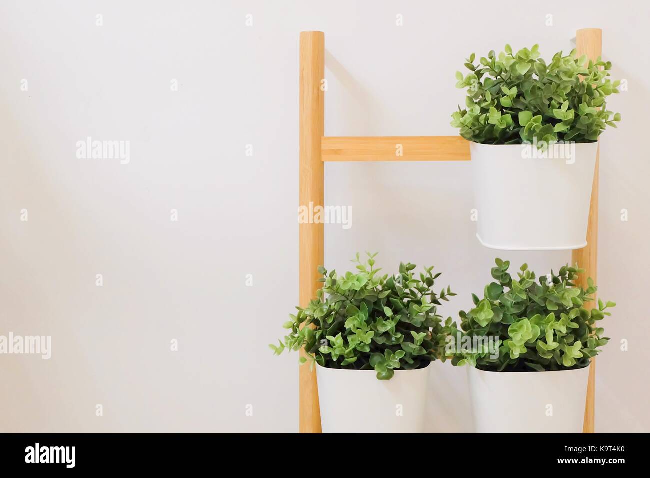 Plantes vertes artificielles dans un pot à fleurs en métal blanc, se tenir sur les étagères en bois, décoration pour la maison et le bureau sans l'attention. Banque D'Images