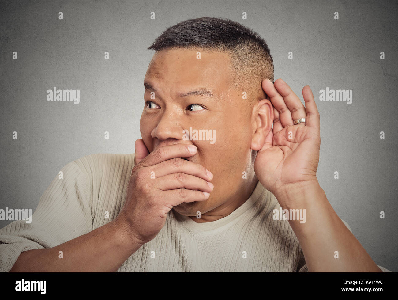 Portrait de l'homme, part de l'oreille pour écouter secrètement en geste d'essayer sur des commérages juteux conversation actualités violation de la vie privée, choqué par ce qu'il entendra, isolé Banque D'Images