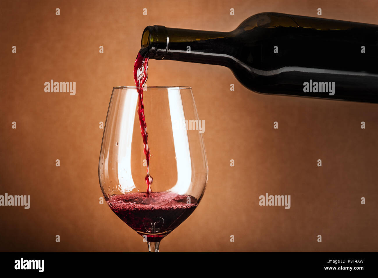 Vin rouge versé dans le verre de la bouteille Banque D'Images