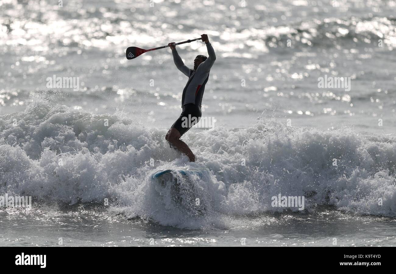 Un paddleboarder surfe une vague de east wittering beach dans le West Sussex. Banque D'Images