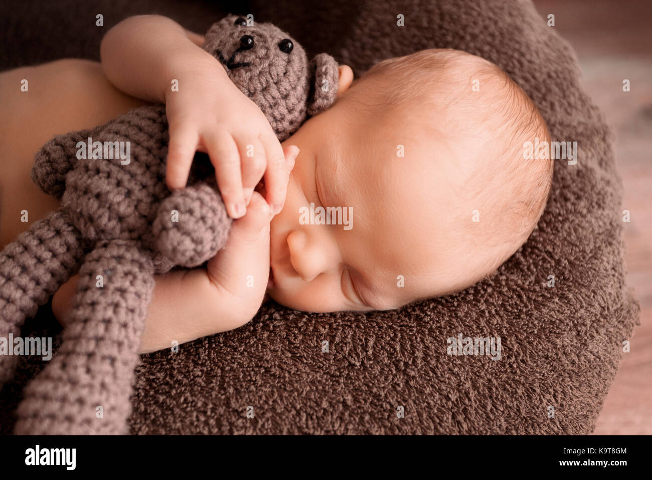 Bébé nouveau-né de dormir dans une belle pose avec un petit ours Banque D'Images