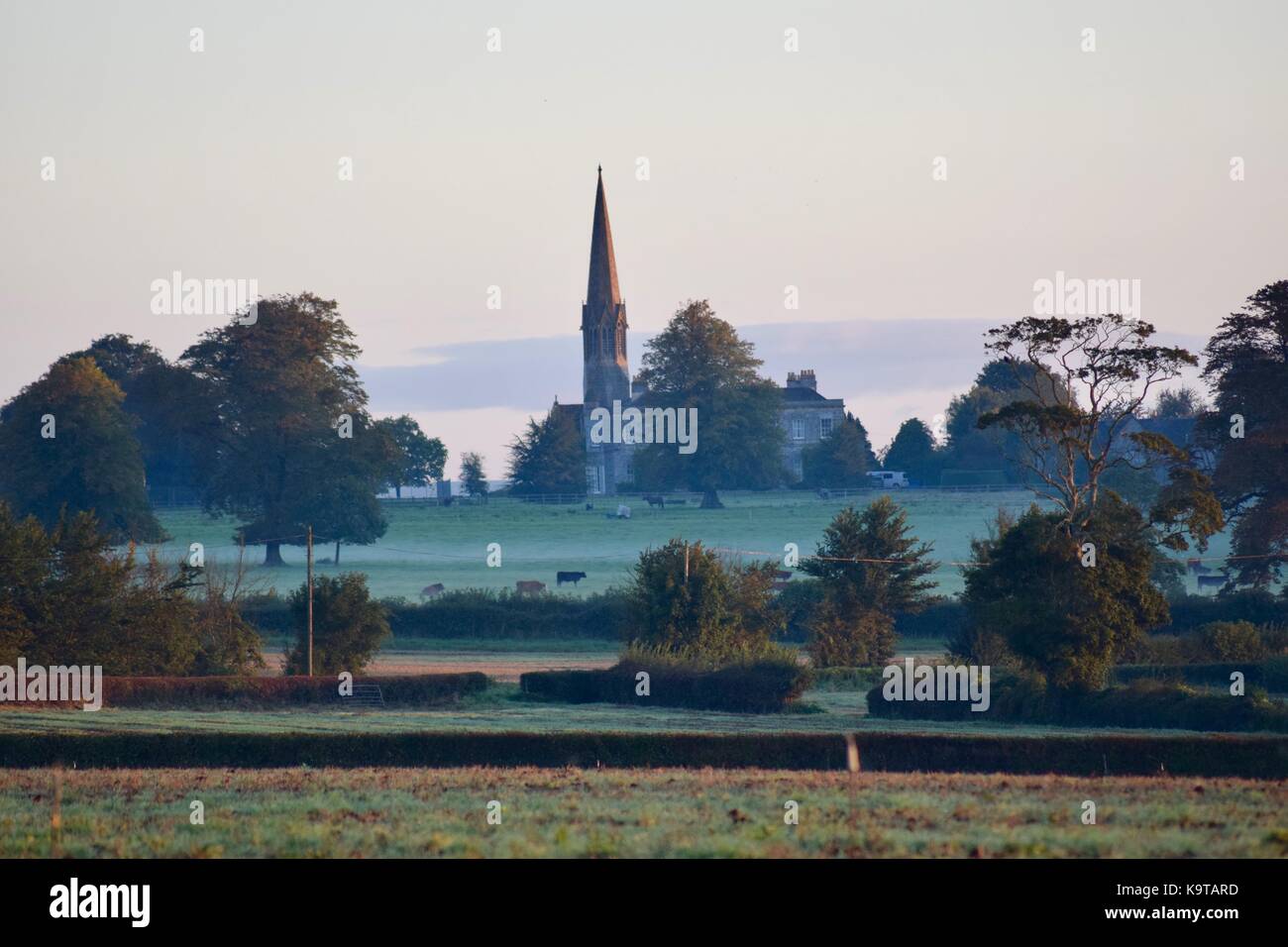 Lever du soleil sur les champs et le parcours de golf dans le petit village de Kingweston Somerset UK avec l'église en arrière-plan Banque D'Images